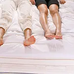 Couple laying next to each other on a bed