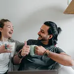 Couple sitting on couch smiling at each other