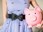 Woman in a dress holding a large piggy-bank