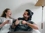 Couple sitting on couch smiling at each other