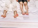 Couple laying next to each other on a bed